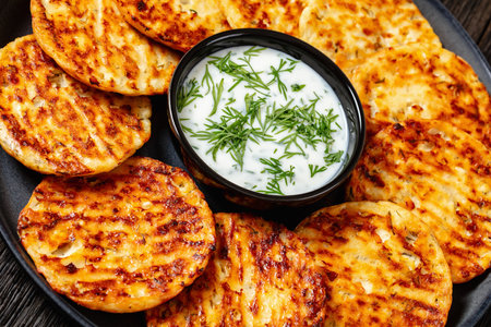 baked in oven high protein savory cottage cheese parmesan and dill pancakes on plate with sour cream, Dutch angle view, close-upの写真素材