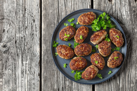 frikadeller, danish meatballs on gray plate on rustic wooden table, horizontal view from above, flat lay, free spaceの写真素材