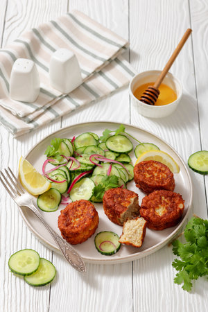 fiskefrikadeller, dutch fishcakes of ground fish fillet served with cucumber salad on a plate on white wooden table, vertical view from above, real photo, not AI generatedの写真素材