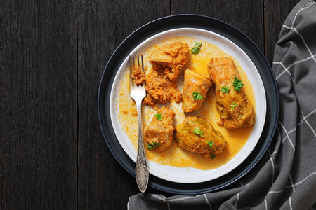 cabbage rolls with quinoa and ground chicken filling on a plate on dark wood table with fork horizontal view from above, flat lay, free space, real photoの写真素材