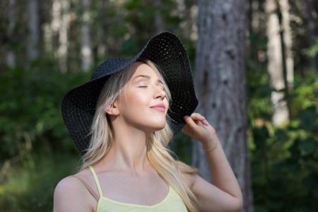 Bright stylish lifestyle portrait of pretty girl posing at hat. Outdoor vacationの写真素材