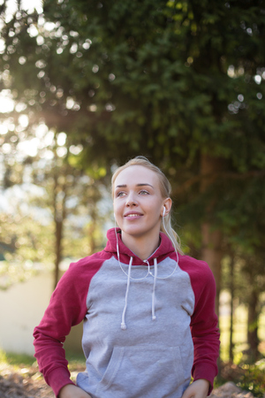 Young female runner in hoody is jogging in natureの写真素材