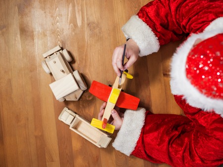 Santa Claus making toys. Painting and coloring wooden toyの写真素材