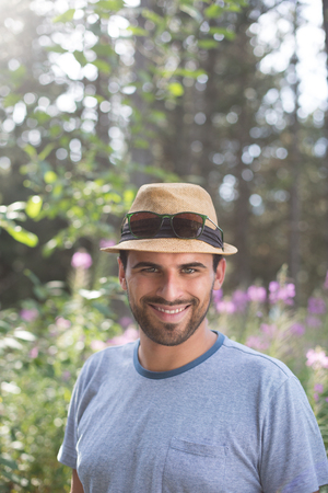Handsome hipster smiling at camera on a sunny dayの写真素材