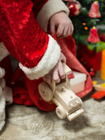 holidays, celebration and people concept - close up of santa claus putting present under christmas treeの写真素材