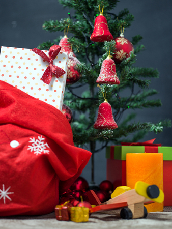 Photo of luxury gift boxes under Christmas tree, New Year home decorations, golden wrapping of Santa presents, festive fir tree decorated with garland, baubles and angels, traditional celebrationの写真素材