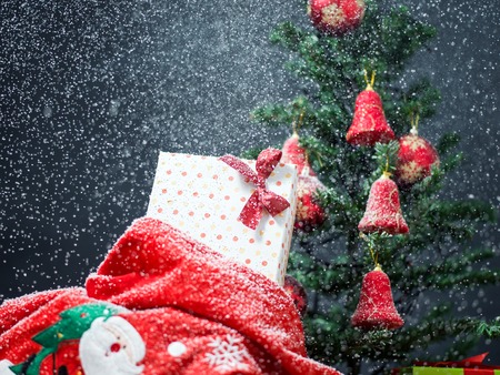 Photo of luxury gift boxes under Christmas tree, New Year home decorations, golden wrapping of Santa presents, festive fir tree decorated with garland, baubles and angels, traditional celebrationの写真素材