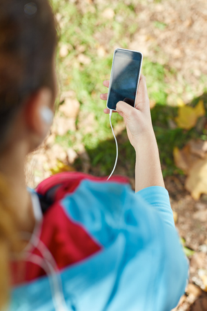 Young Sporty Woman Taking a Selfie at Park. She is Looking at Smart Phoneの写真素材