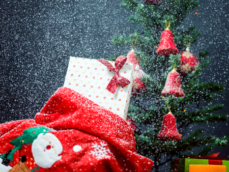 Photo of luxury gift boxes under Christmas tree, New Year home decorations, golden wrapping of Santa presents, festive fir tree decorated with garland, baubles and angels, traditional celebrationの写真素材