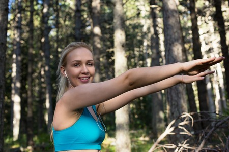 Blonde woman running outside and stretchingの写真素材