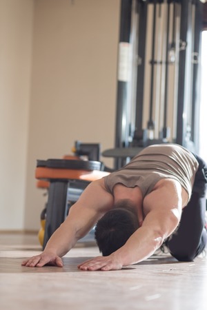 young man doing yoga in the gymの写真素材
