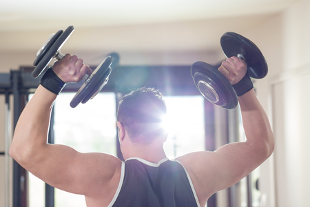 Young Man Working Out Biceps - Dumbbell Concentration Curlsの写真素材