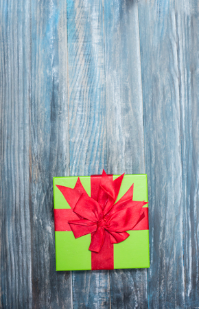 Christmas Present wrapped in  paper on a wooden background for a voucher coupon - greeting card country styleの写真素材