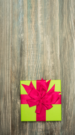 Christmas Present wrapped in  paper on a wooden background for a voucher coupon - greeting card country styleの写真素材