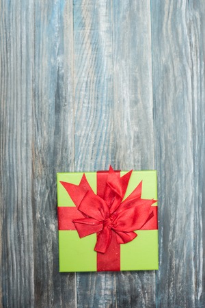 Christmas Present wrapped in  paper on a wooden background for a voucher coupon - greeting card country styleの写真素材
