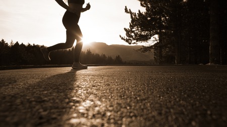 Young lady running in the desert at sunset, retro toneの写真素材