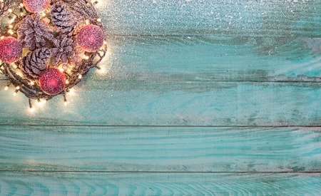 Christmas or New Year decoration background: fur-tree branches, colorful glass balls and glittering stars on blue wooden background, top view, copy spaceの写真素材