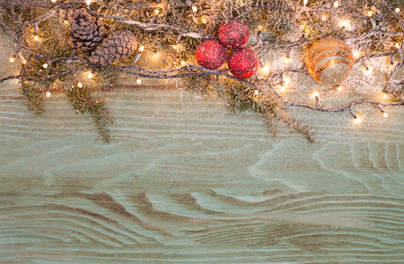 Christmas fir tree with snowfall on a wooden boardの写真素材