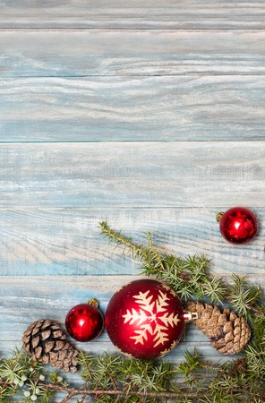 Red Christmas ornaments in the form of a Xmas tree on a rustic wooden background. Merry christmas card. Happy New Year. Top view with copy spaceの写真素材