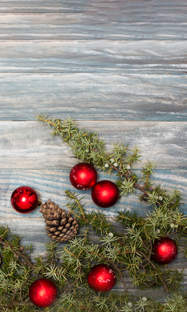 Red Christmas ornaments in the form of a Xmas tree on a rustic wooden background. Merry christmas card. Happy New Year. Top view with copy spaceの写真素材
