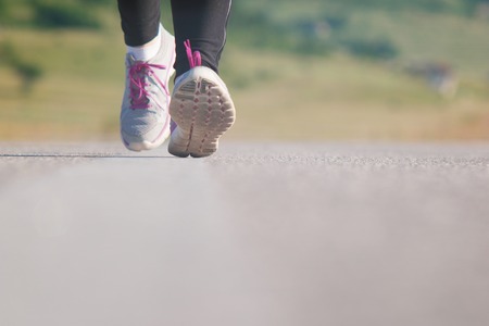 Female athlete runner. closeup on shoe. woman fitness sunset jog workout concept.の写真素材