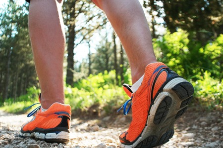 Close up of man walking on nature trail near forest preserve. Color image, copy space, male walking outside on a beautiful day in nature.Horizontalの写真素材