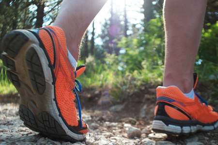 Close up of man walking on nature trail near forest preserve. Color image, copy space, male walking outside on a beautiful day in nature.Horizontalの写真素材