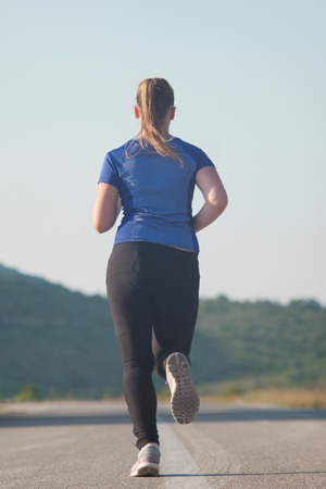 Healthy running runner woman early morning sunrise workout  mountain road workout jogの写真素材
