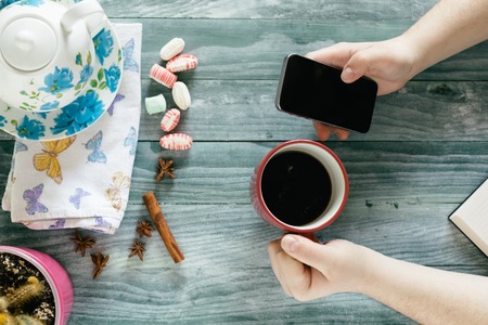 business man using mobile smart phone at wooden table ,smart phone, cup of coffeeの写真素材