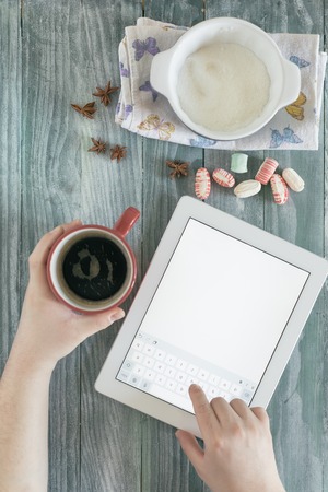 Coffee and tablet on colorful rough wooden tableの写真素材