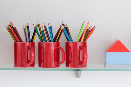Desktop with cup of crayons in classroom,School suppliesの写真素材