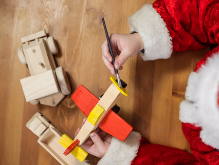 Santa Claus making toys. Painting and coloring wooden toyの写真素材
