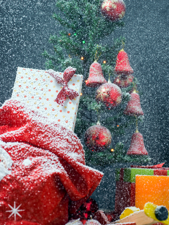 Photo of luxury gift boxes under Christmas tree, New Year home decorations, golden wrapping of Santa presents, festive fir tree decorated with garland, baubles and angels, traditional celebrationの写真素材