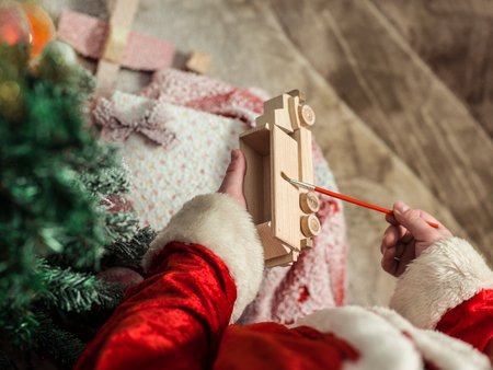 Santa Claus painting wooden toy with gouacheの写真素材