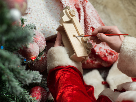 Santa Claus painting wooden toy with gouacheの写真素材