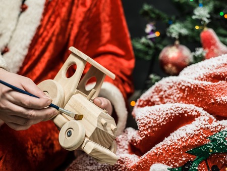 Santa Claus painting wooden toy with gouacheの写真素材
