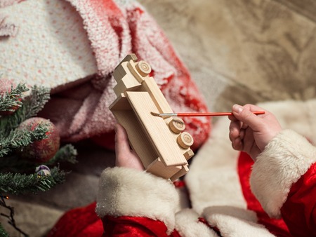 Santa Claus painting wooden toy with gouacheの写真素材