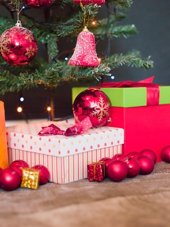 Christmas presents with red ribbon on dark wooden background in vintage styleの写真素材