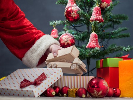 Santa Claus at Home putting gifts under Christmas Treeの写真素材