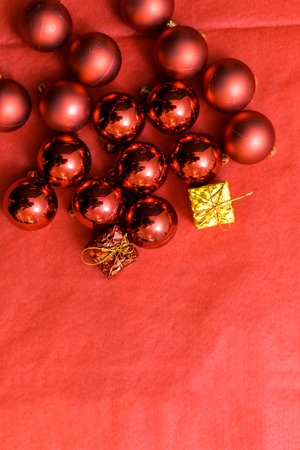 Christmas background with a red ornament, golden gift box and fir in snowの写真素材