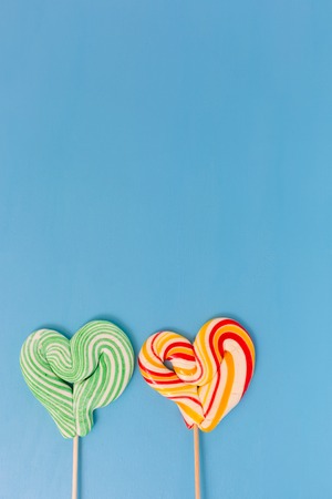 Heart shaped lollipop for Valentine's Day with turquoise background. Copy space backgroundの写真素材