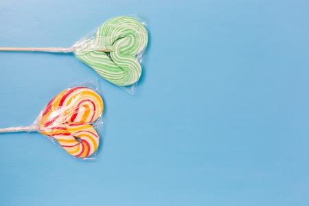 Heart shaped lollipop for Valentine's Day with turquoise background. Copy space backgroundの写真素材