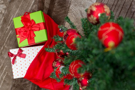 Christmas tree with gift box and decorations on wooden background space for letteringの写真素材