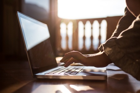 Image of black laptop keyboard with female hands touching it, selective focusの写真素材