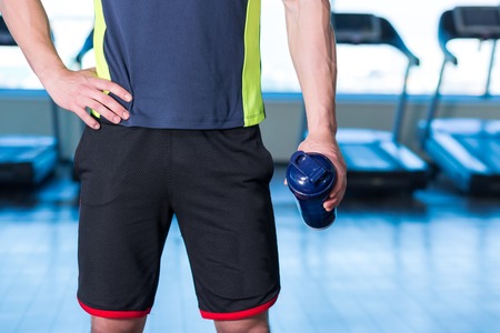 Closeup of man in gym with blue shakerの写真素材