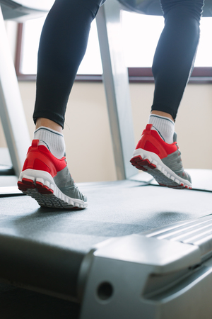 Man running in a gym on a treadmill concept for exercising, fitness and healthy lifestyleの写真素材
