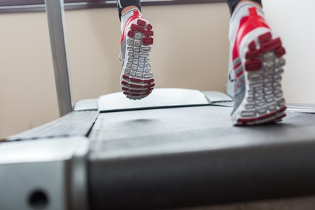 Man running in a gym on a treadmill concept for exercising, fitness and healthy lifestyleの写真素材