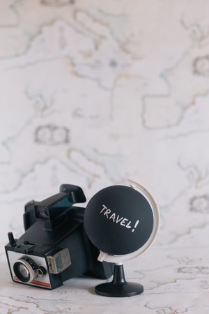 Camera and globe with travel letters on itの写真素材