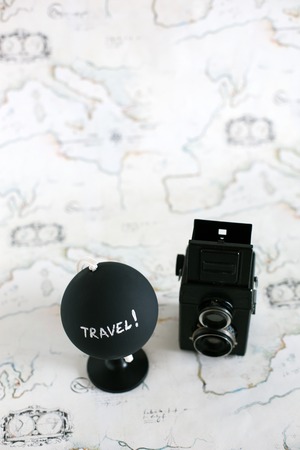 Camera and globe with travel letters on itの写真素材