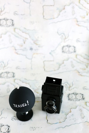 Camera and globe with travel letters on itの写真素材